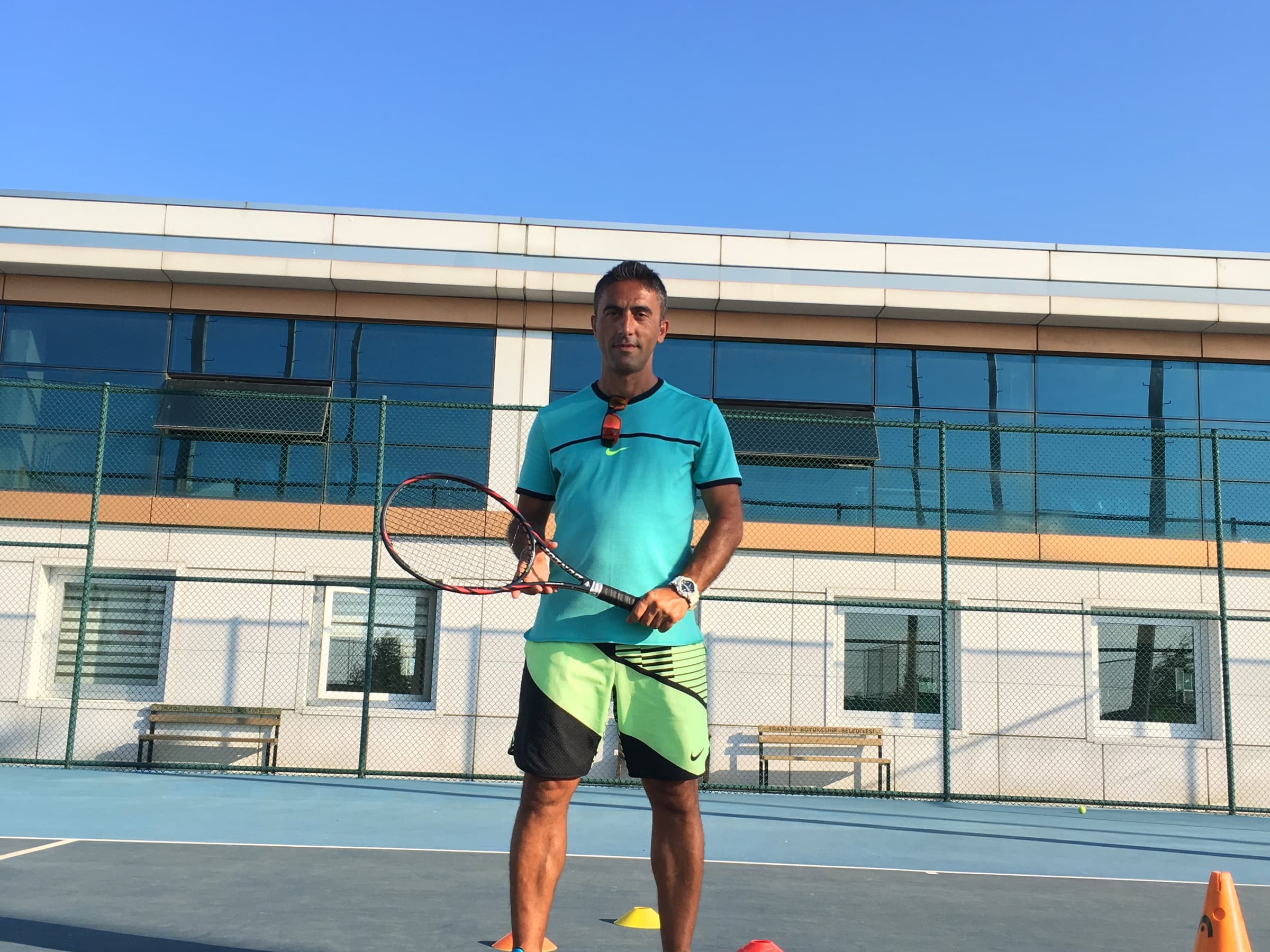 Barış Engin — mavi kortta raketiyle vuruş pozisyonunda duran Trabzon Tenis Kulübü antrenörü