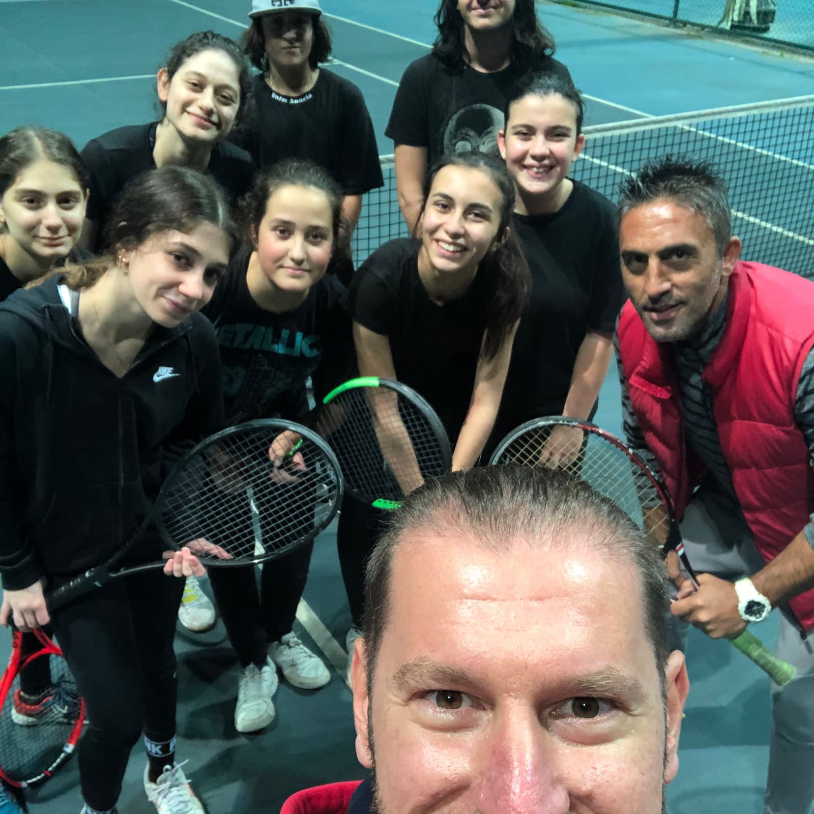 Antrenörün raketleriyle poz veren genç sporcu grubuyla çektiği selfie